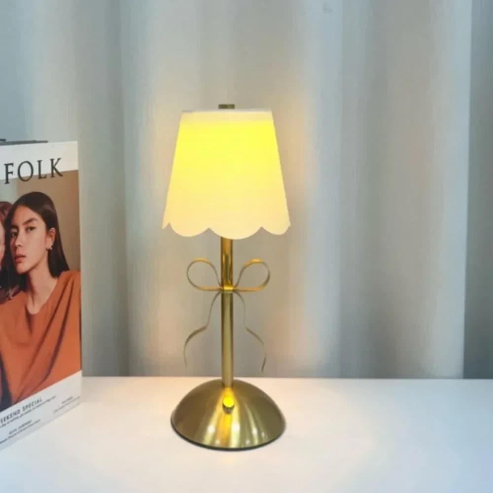 Genopladelig bordlampe med gyldent sløjfe og stofskærm